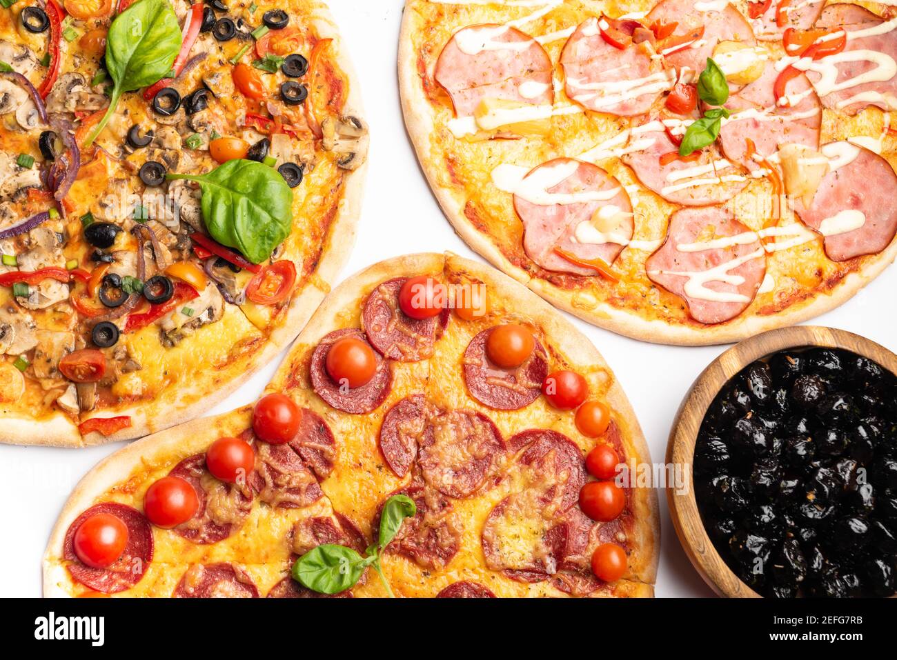 différentes sortes de pizzas dans assortiment avec basilic vert, champignons, tomates, fromage, poivre pour le menu. Gros plan. Repas de restauration rapide ou pizza de fête dinn Banque D'Images