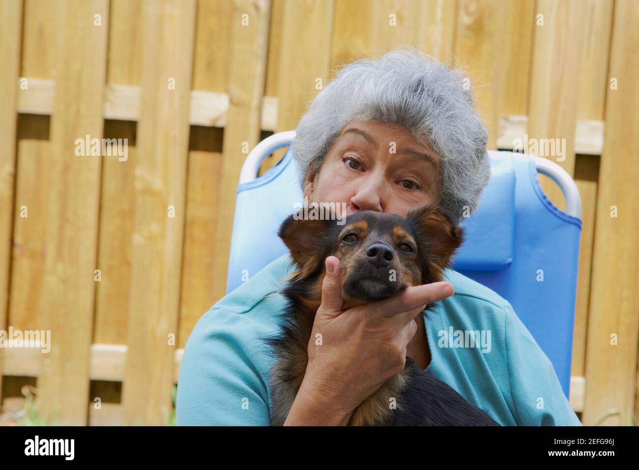 Portrait of a senior woman kissing un chien Banque D'Images