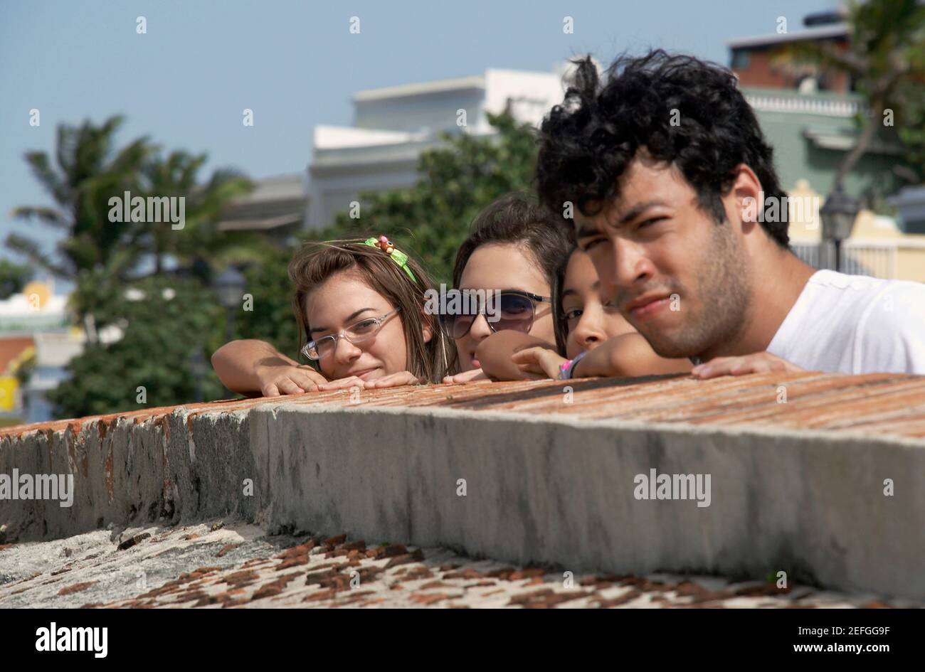 Portrait d'un jeune homme avec trois jeunes femmes à plus d'un mur de château, Château del Morro, Old San Juan, San Juan, Puerto Rico Banque D'Images