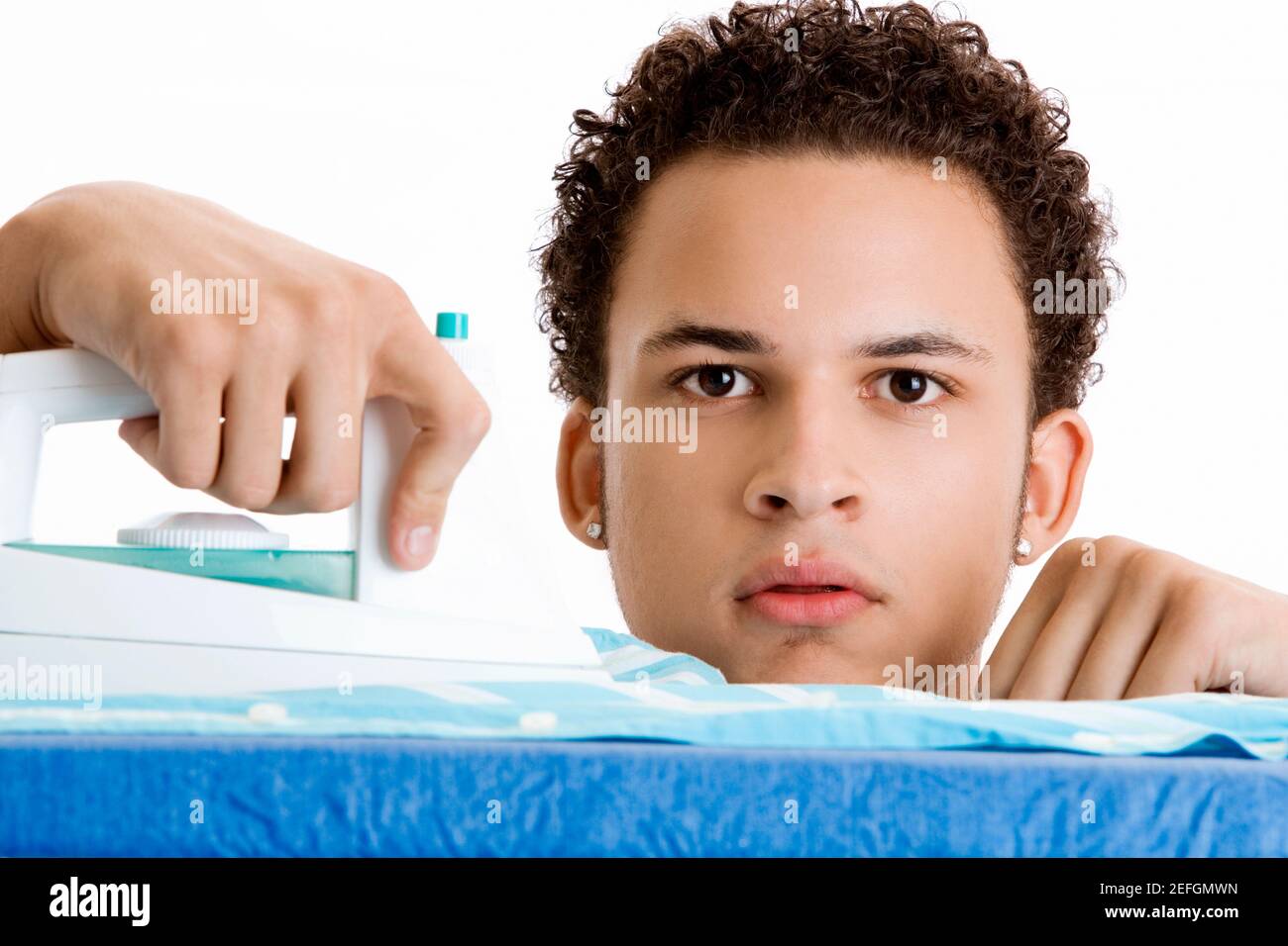 Portrait d'un jeune homme repassant sa chemise Banque D'Images