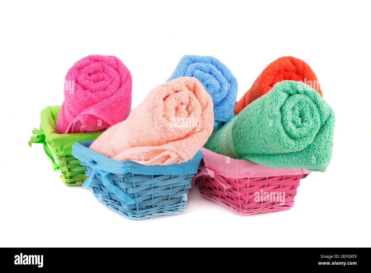 Rouleaux de serviettes colorées dans des paniers en bambou isolés sur fond blanc. Banque D'Images