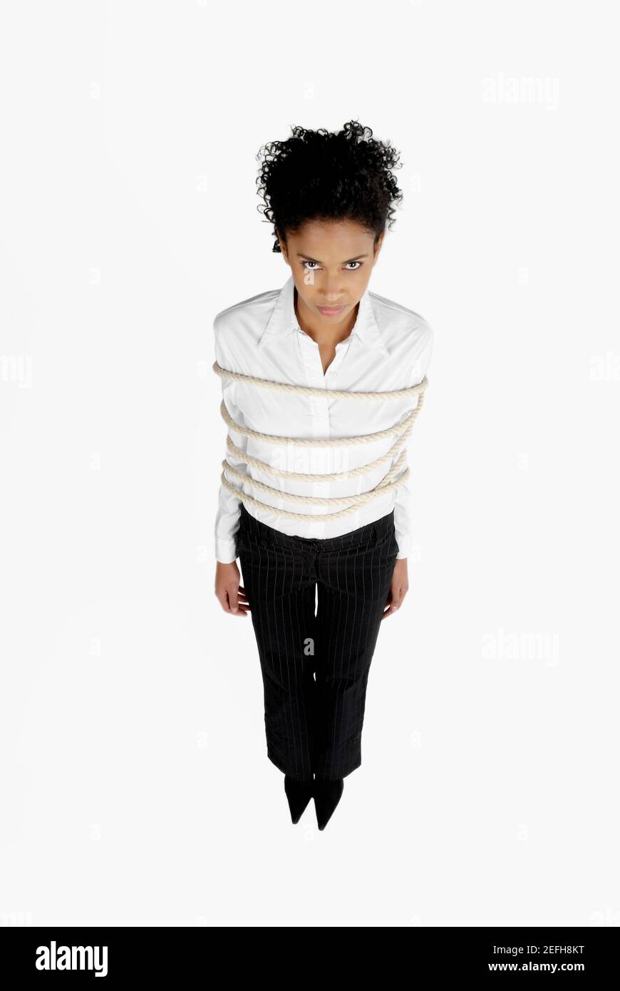 Vue en grand angle d'une femme d'affaires attachée avec une corde Banque D'Images