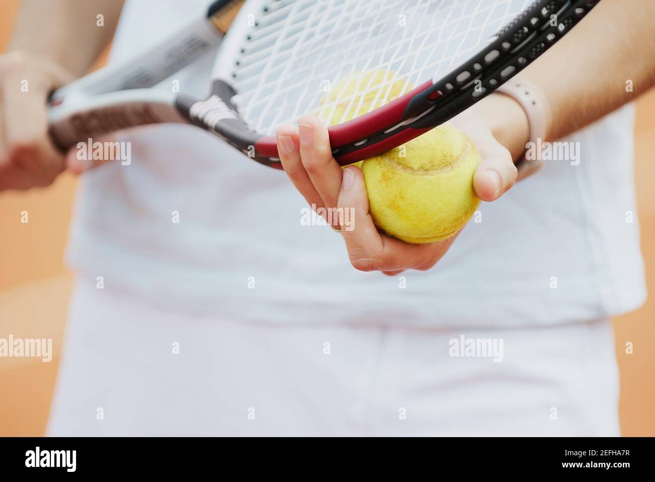 Vue en section centrale d'une joueuse de tennis tenant un une raquette de tennis et une balle de tennis Banque D'Images