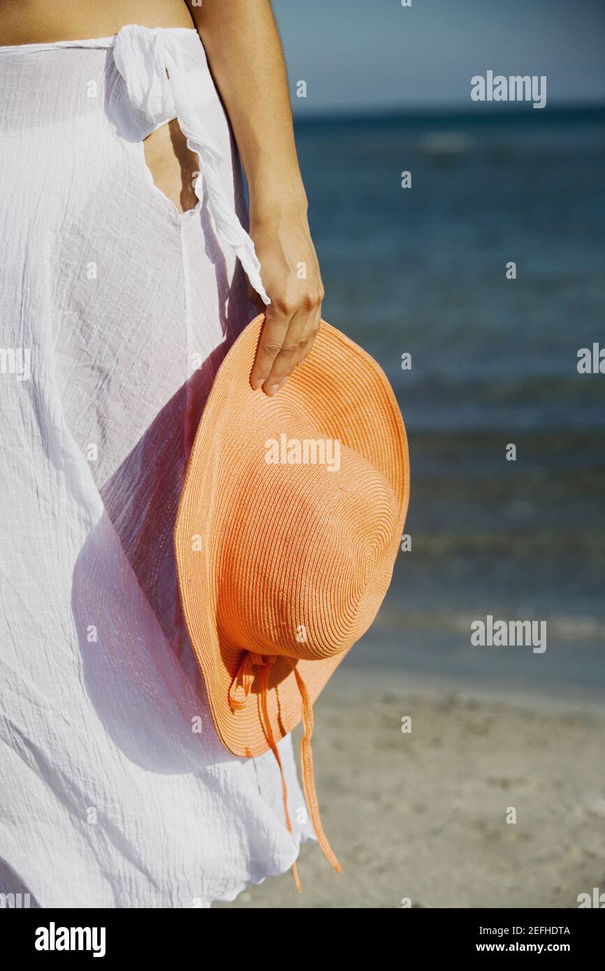 Vue en coupe centrale d'une femme tenant un chapeau la plage Banque D'Images