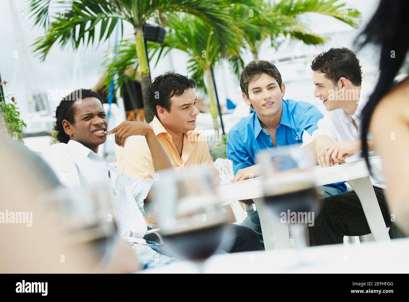 Quatre jeunes hommes assis dans un restaurant Banque D'Images