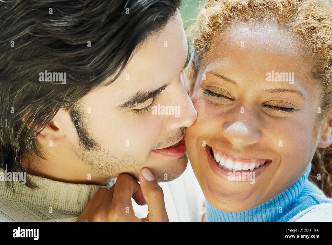 Gros plan d'un jeune homme embrassant une jeune femme Banque D'Images