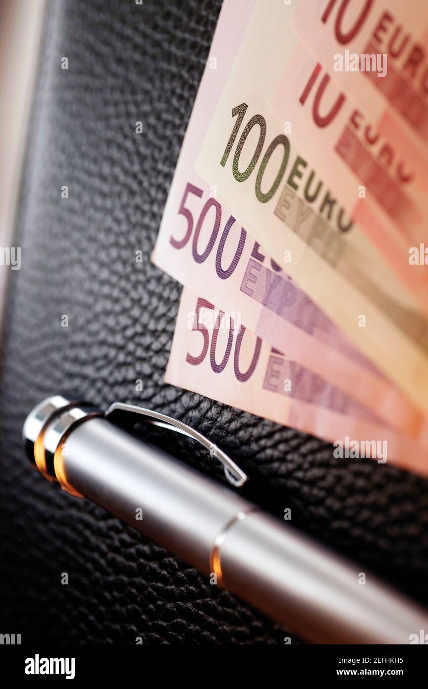 Plusieurs billets de banque en euros avec stylo sur le dessus du portefeuille, gros plan Banque D'Images