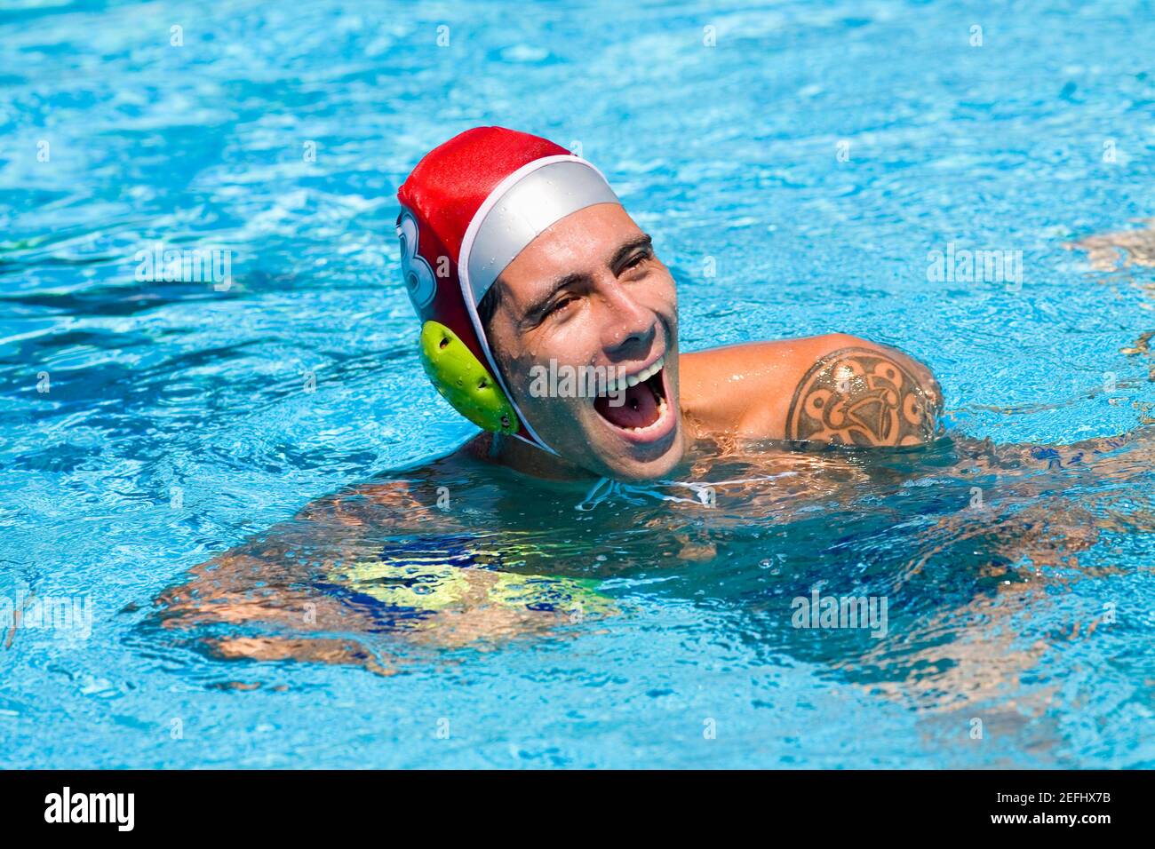 Homme de taille moyenne jouant au water-polo dans une piscine Banque D'Images