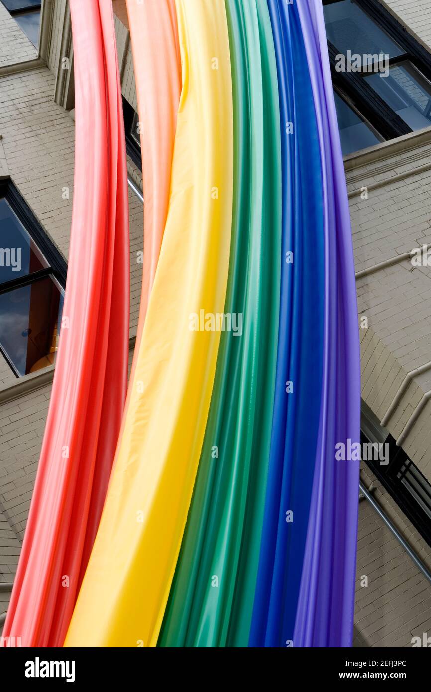 Vue à angle bas d'un drapeau arc-en-ciel suspendu sur un bâtiment Banque D'Images