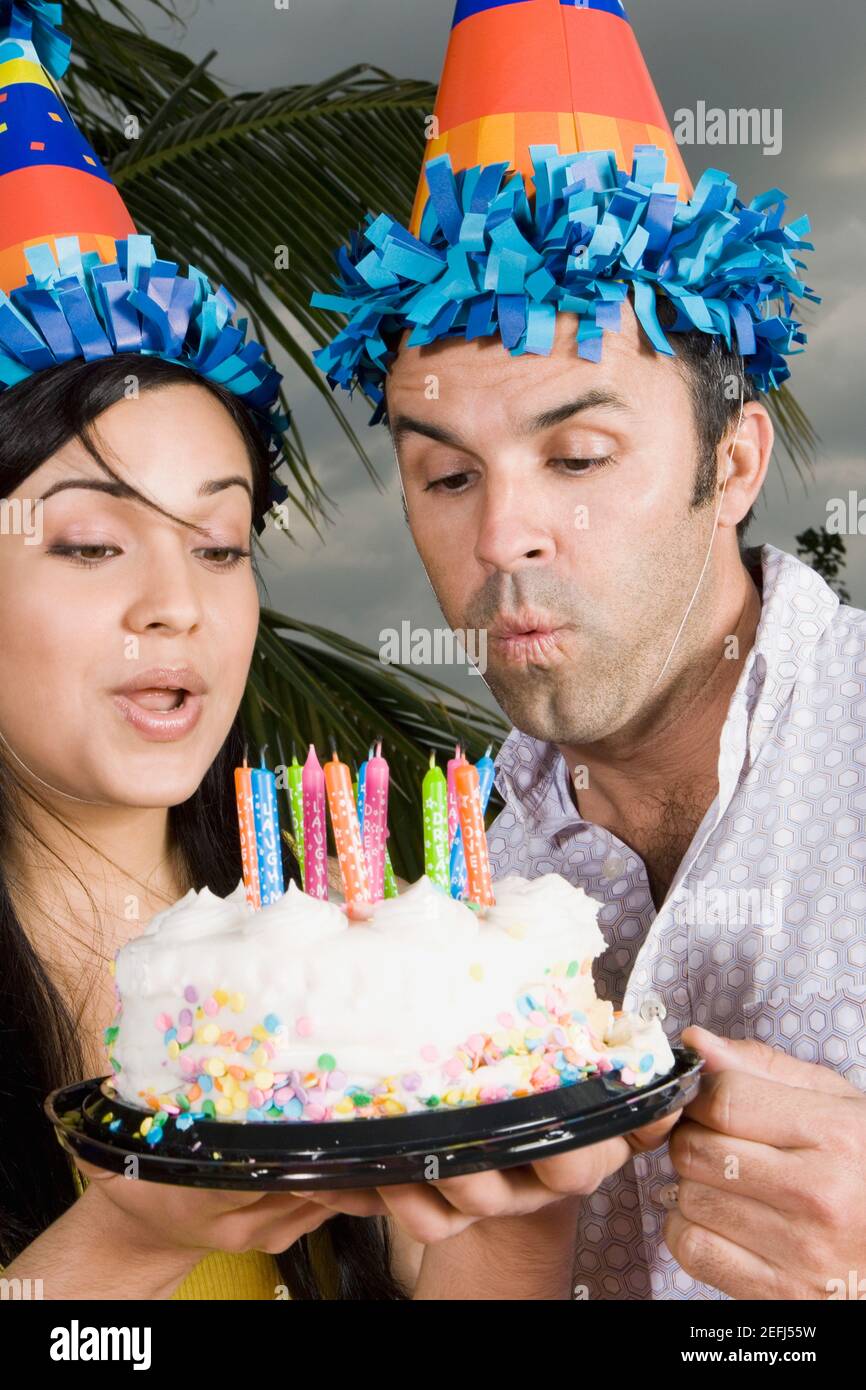 Gros Plan D Une Jeune Femme Avec Un Homme Adulte Moyen Bougies Soufflantes Sur Un Gateau D Anniversaire Photo Stock Alamy