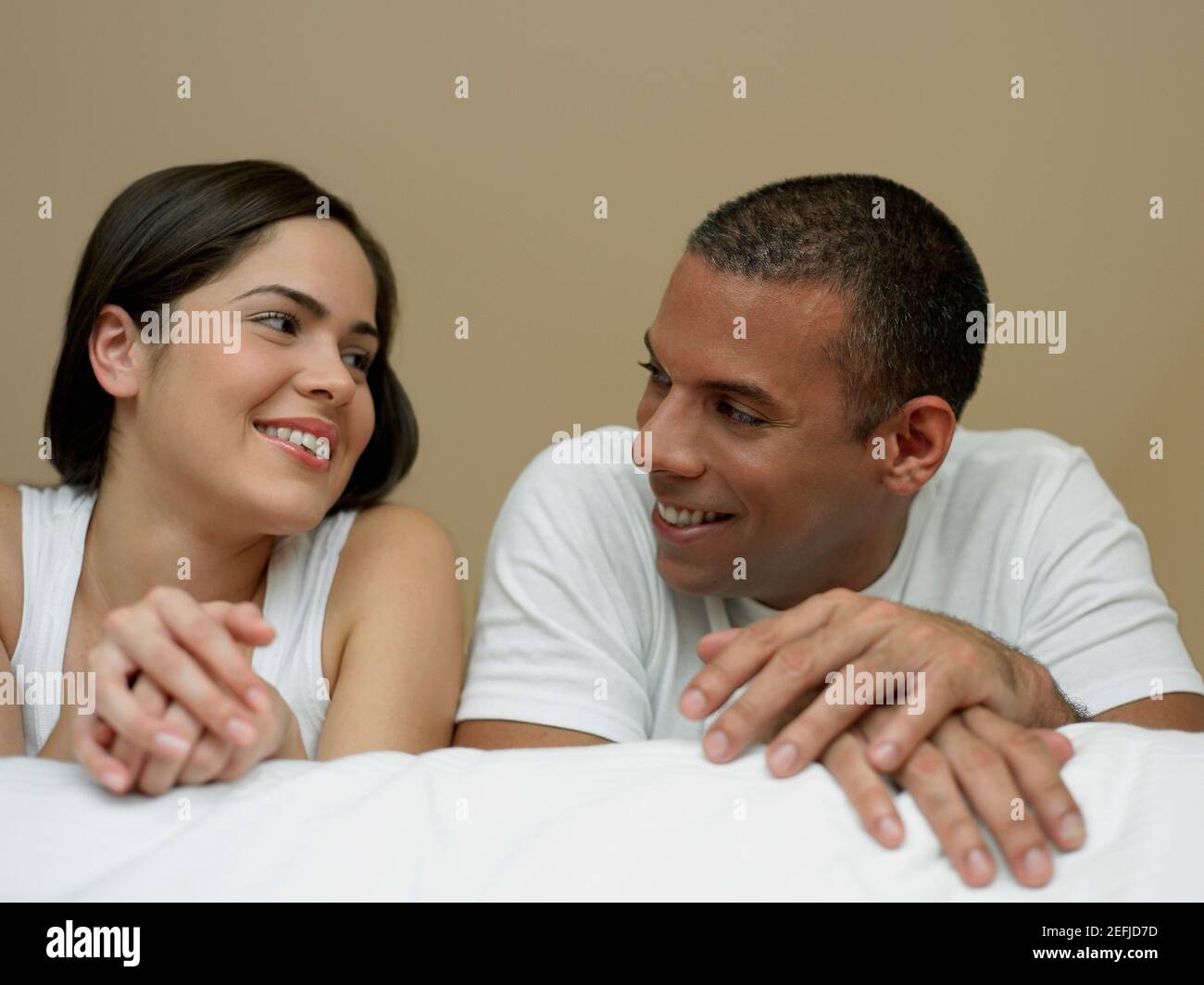 Gros plan d'une jeune femme et d'un homme adulte moyen se regarder et sourire Banque D'Images
