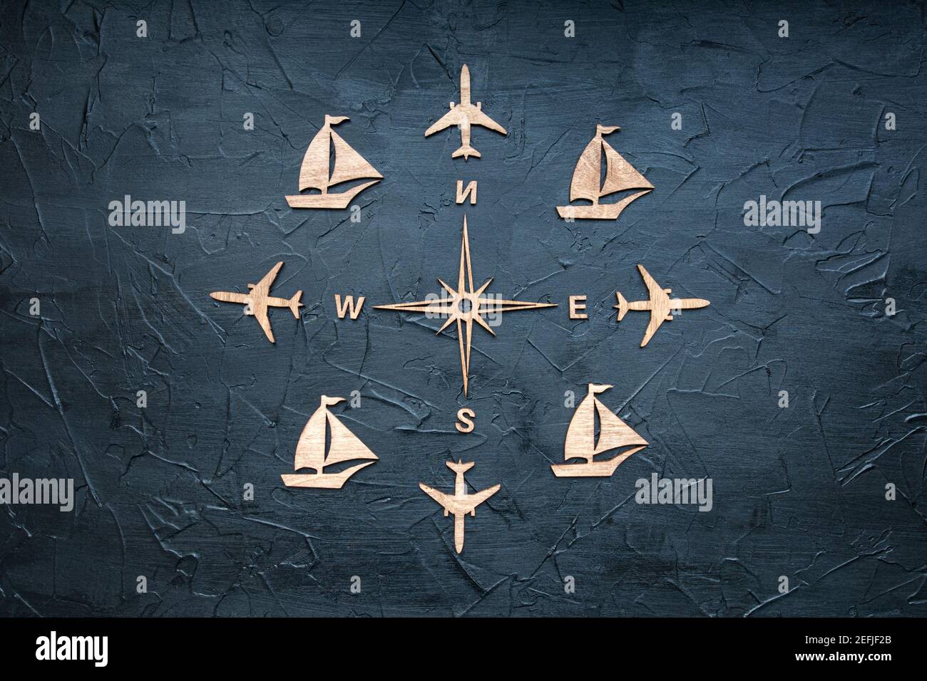 Rose vent et figurines en bois sur le thème du voyage sur fond texturé. Banque D'Images