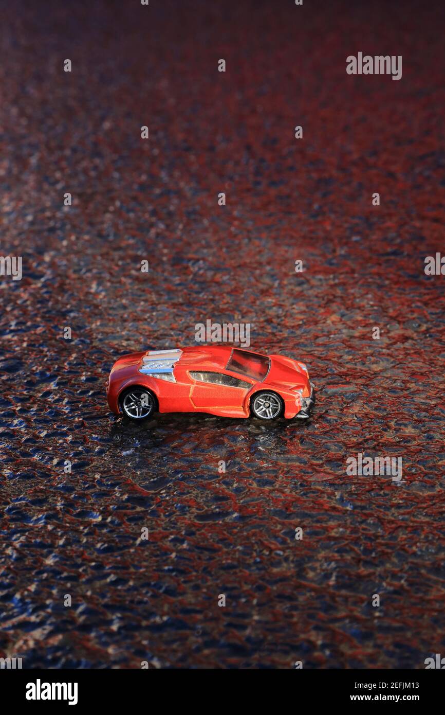 Jouet de voiture de sport rouge sur l'asphalte Banque D'Images