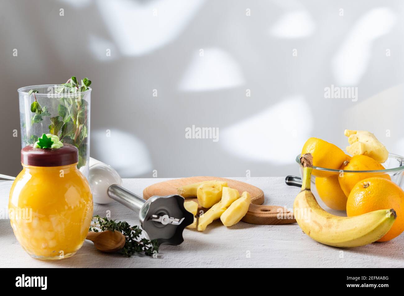 Racine de gingembre pelée sur la table. L'ombre des arbres de la fenêtre sur le mur. Cuisine. Banque D'Images