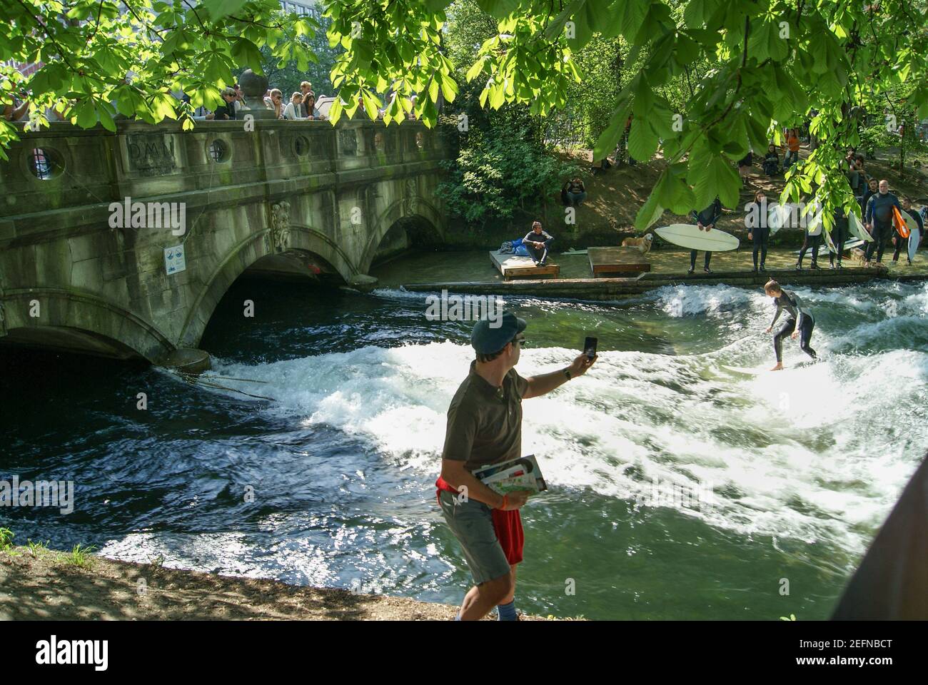 Munich, Allemagne - avril 2011 : un surfeur à cheval sur la vague d'Eisbach. Cette rivière faite par l'homme est un bras de la rivière Isar dans le parc Englischer Garten Banque D'Images