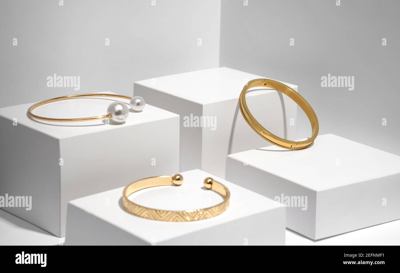 Trois bracelets dorés modernes sur des boîtes blanches Banque D'Images