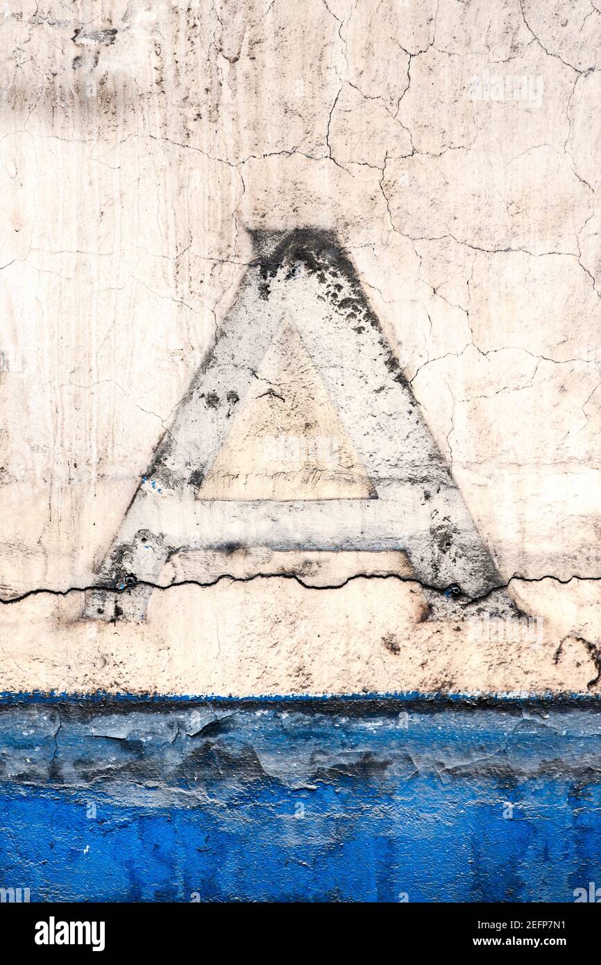 A résisté aux restes d'une lettre majuscule A sur une maison mur Banque D'Images