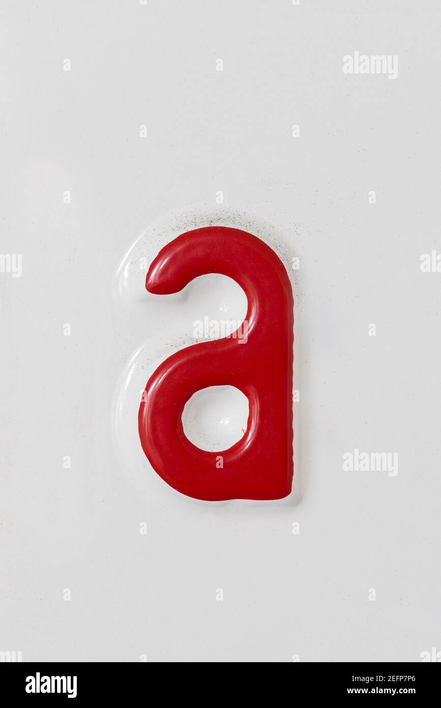 Lettre rouge en relief a sur une plaque en étain blanc Banque D'Images