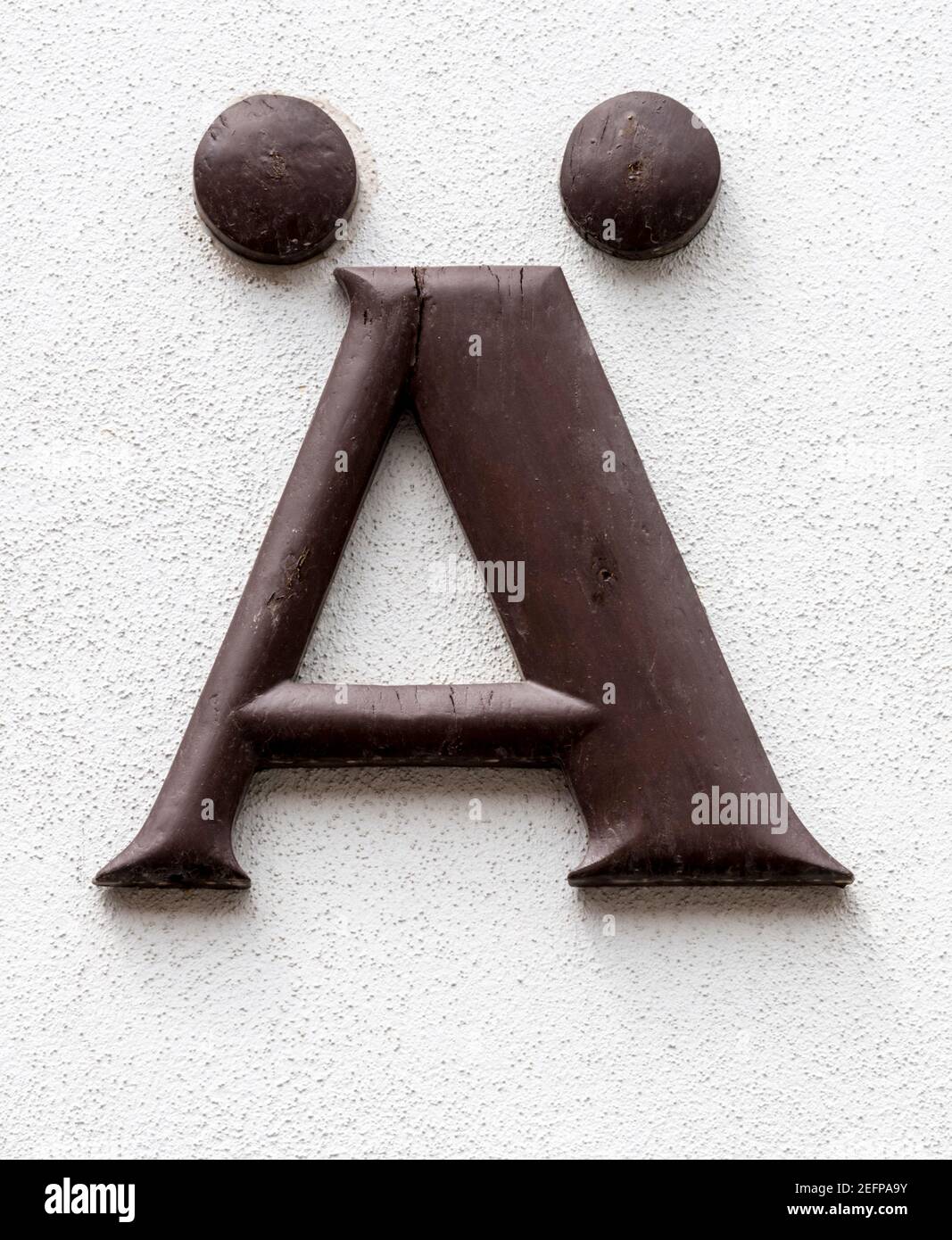 Lettre AE/Ä en bois marron sur mur clair Banque D'Images