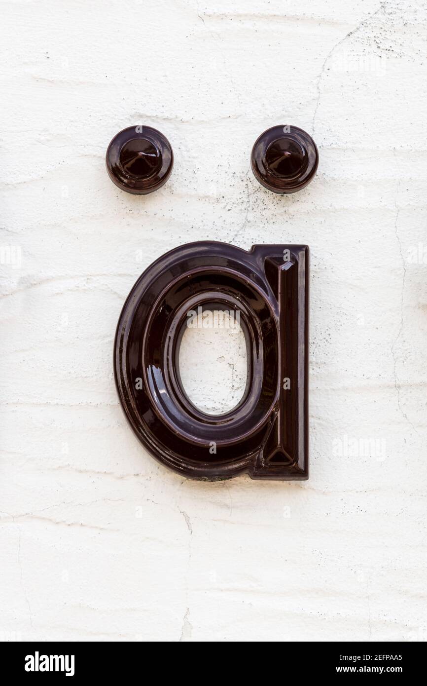 Lettre émaillée marron foncé ä/ae sur mur clair Banque D'Images