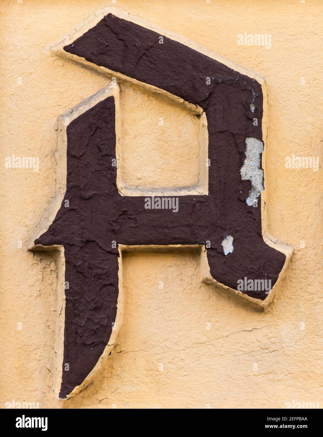 Lettre MARRON A en rupture sur fond jaune ocre Banque D'Images