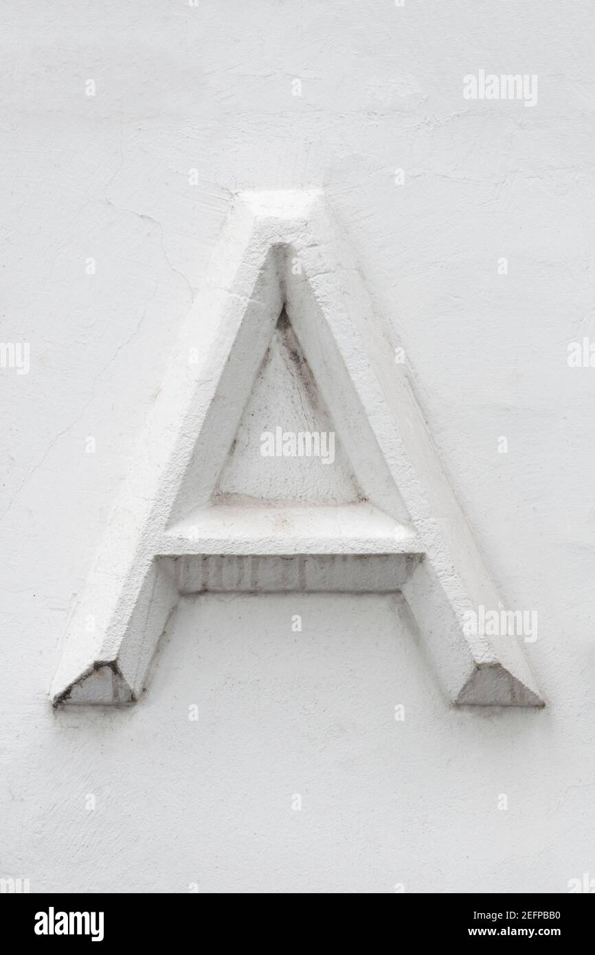 Lettre A en stuc blanc sur sol blanc Banque D'Images