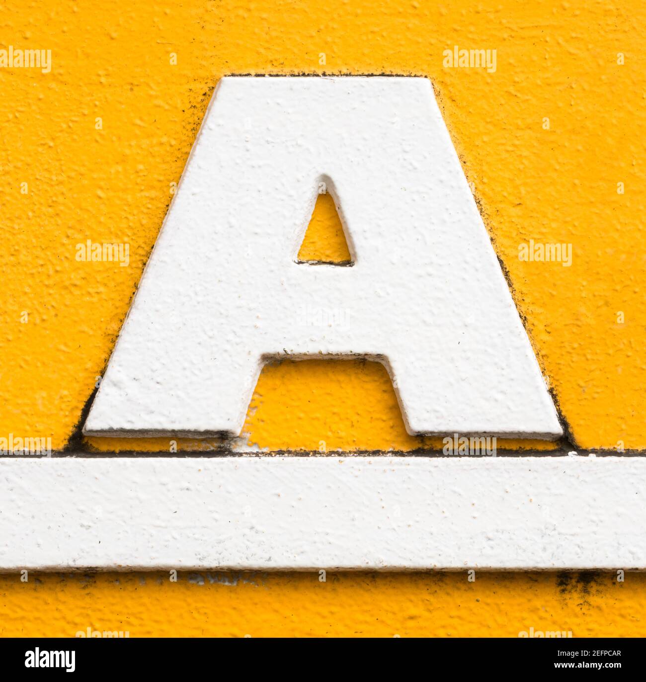 Lettre A en métal blanc avec soulignement blanc sur fond jaune Banque D'Images