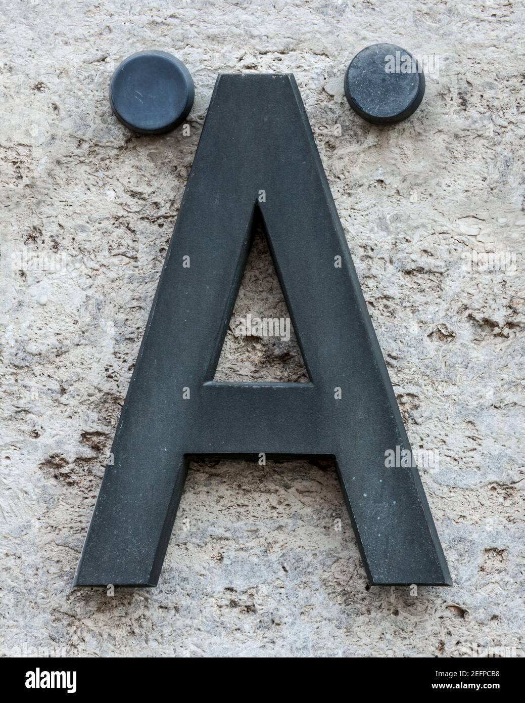 Lettre en métal Ä (AE) sur un mur en pierre Banque D'Images