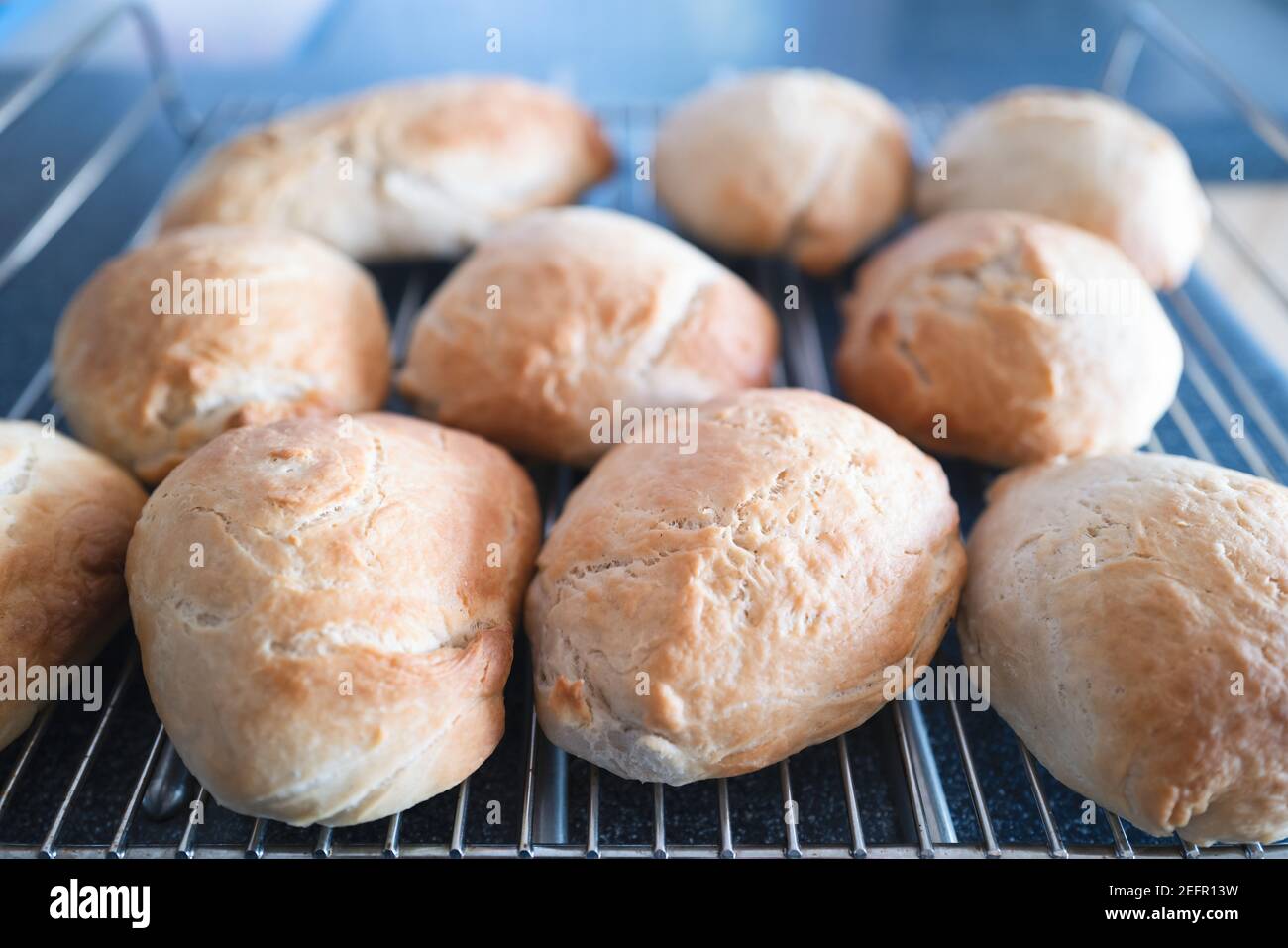 Petits pains frais croustillants refroidissant sur une grille métallique. Mise au point peu profonde Banque D'Images