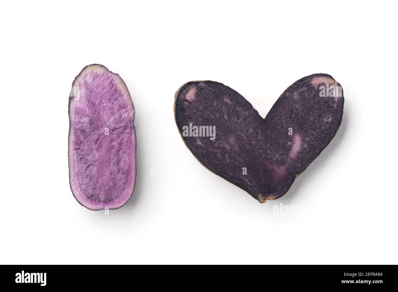 I symboles coeur fabriqués par des tranches de pommes de terre bleues violets isolées sur fond blanc. Banque D'Images