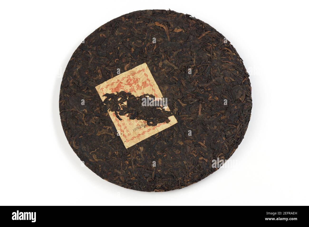 Pu'er ou pu-erh, thé chinois fermenté, vieilli ou mûri pendant plus de 20 ans à partir de 1999, pressé en forme de gâteau rond. Thé noir chinois. Disque isolé Banque D'Images