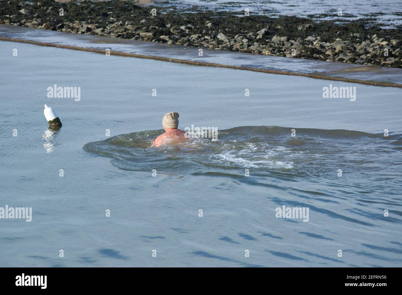 Homme nageant en eau froide pendant l'hiver. Banque D'Images