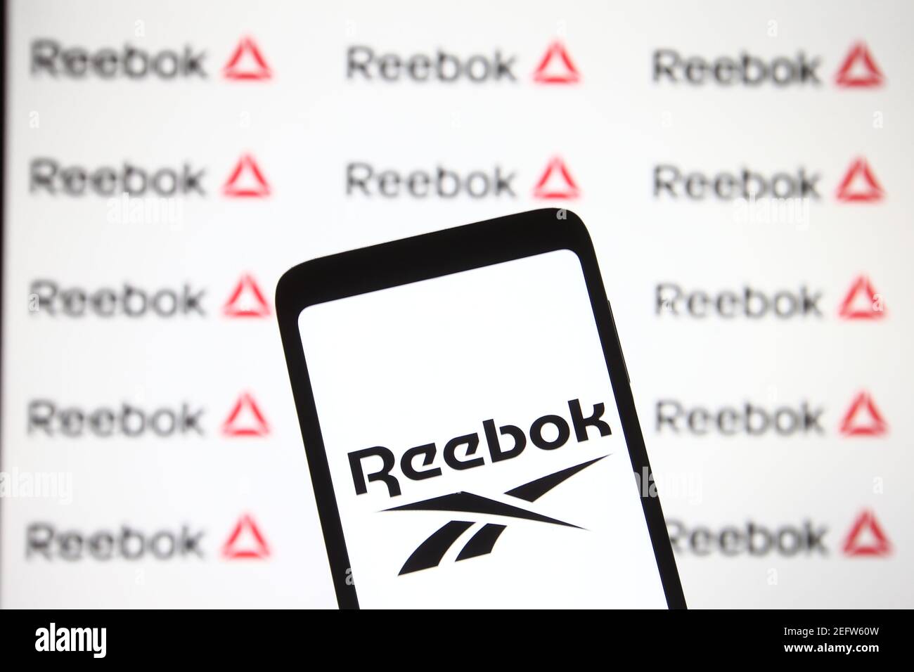 Dans cette illustration, le logo Reebok apparaît sur un smartphone et un écran de pc. Banque D'Images