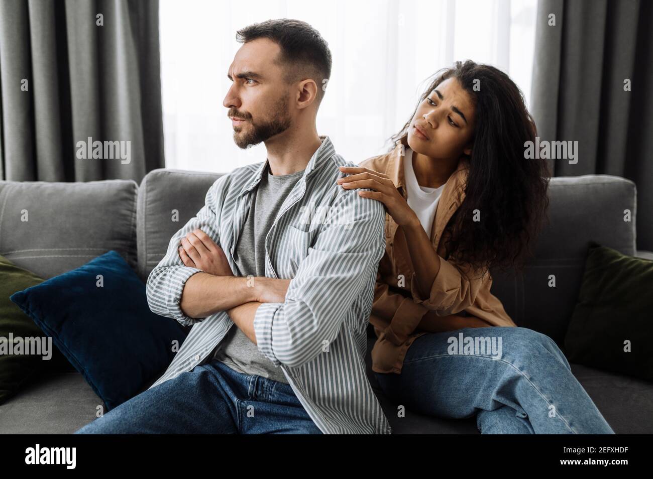 Un couple marié découvre la relation, une querelle entre les amoureux. Couple multiracial dans l'amour se querelant à la maison sur le canapé pour des problèmes de ménage ou de finances. Concept de conflits familiaux domestiques Banque D'Images