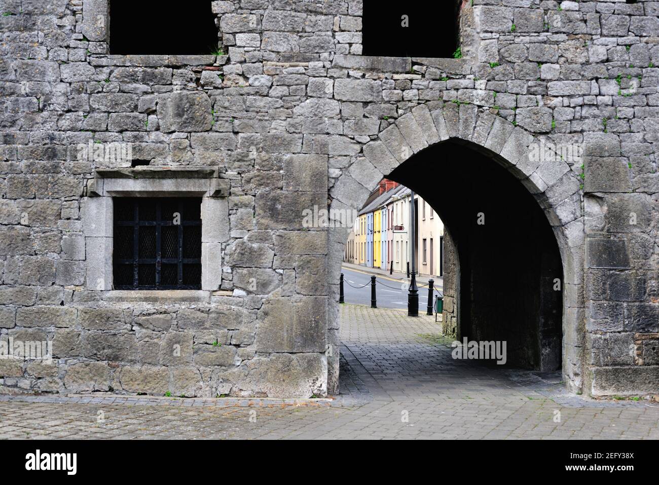 Kilmalock, Comté de Limerick, Irlande. Bâtiments colorés visibles par un portail dans le château du roi John. Banque D'Images