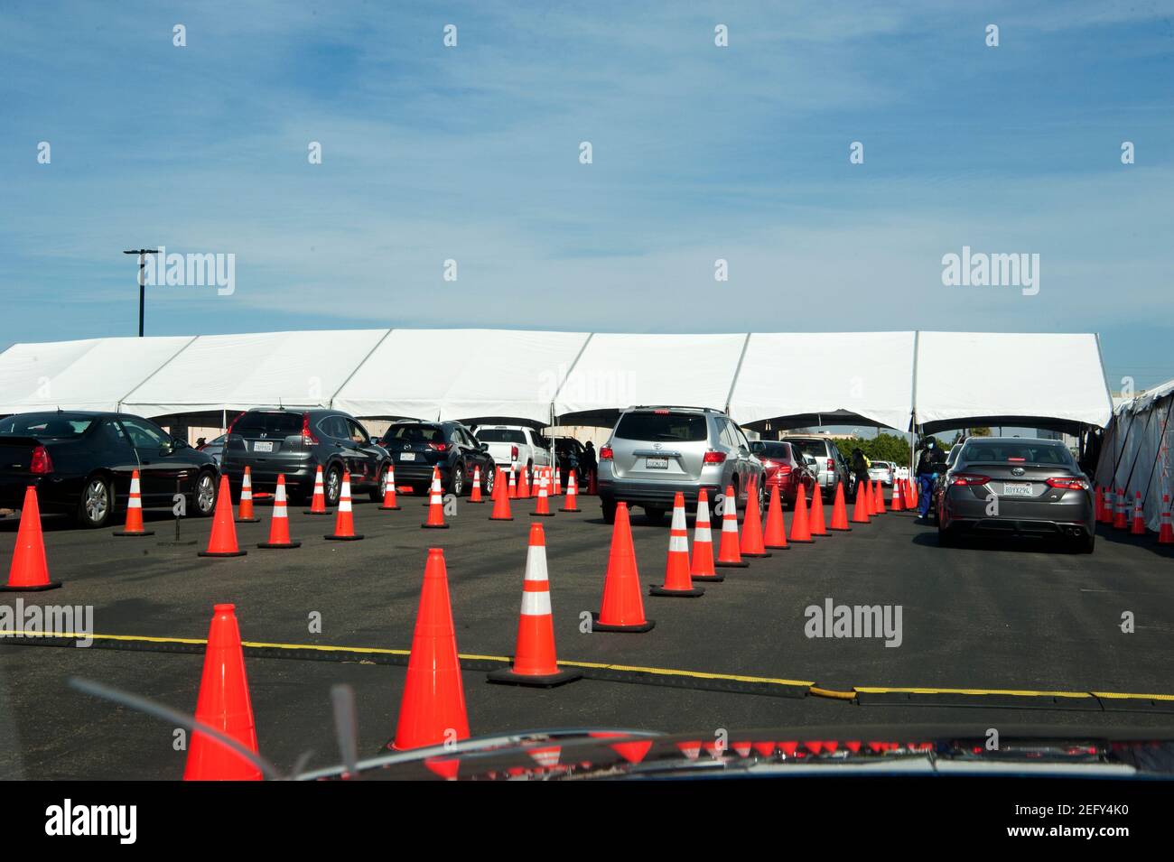 Voitures alignées entre les cônes de trafic orange pour les tirs de vaccination Covid, Downey, CA Banque D'Images