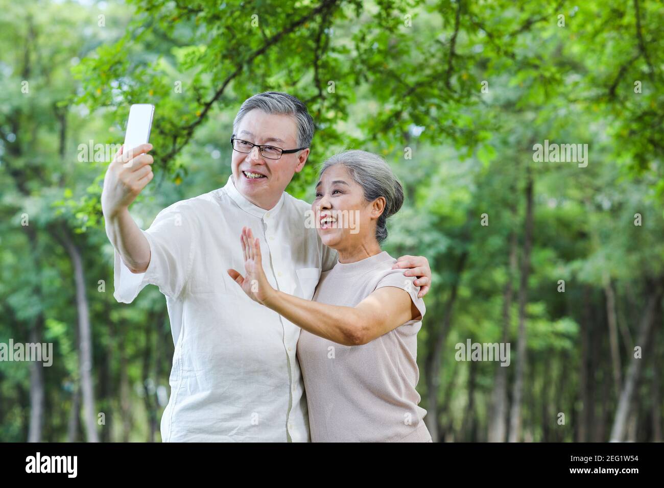Bon vieux couple prendre selfie avec le téléphone mobile dans le stationnement Banque D'Images