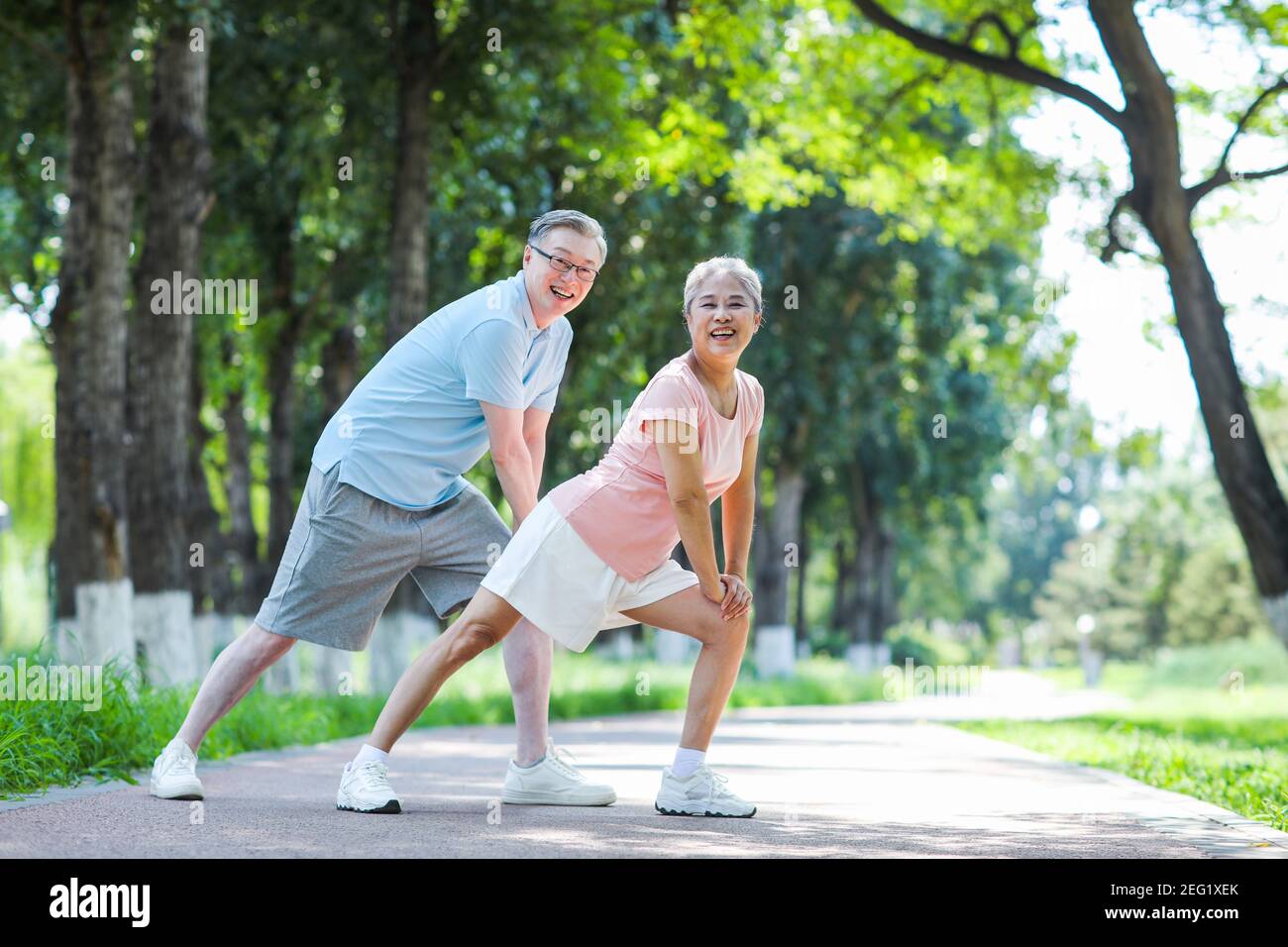 Vieux couple sportif dans le parc souriant Banque D'Images