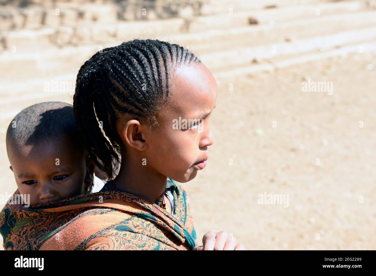 Une fille Tigrayan portant son petit broteur sur le dos. Région du Tigray, Éthiopie. Banque D'Images