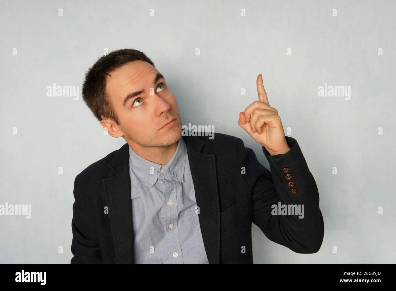 homme d'affaires fait le point avec une expression réfléchie sur fond bleu. Mignon jeune homme donne une présentation. Copier l'espace. CopySpace. Banque D'Images