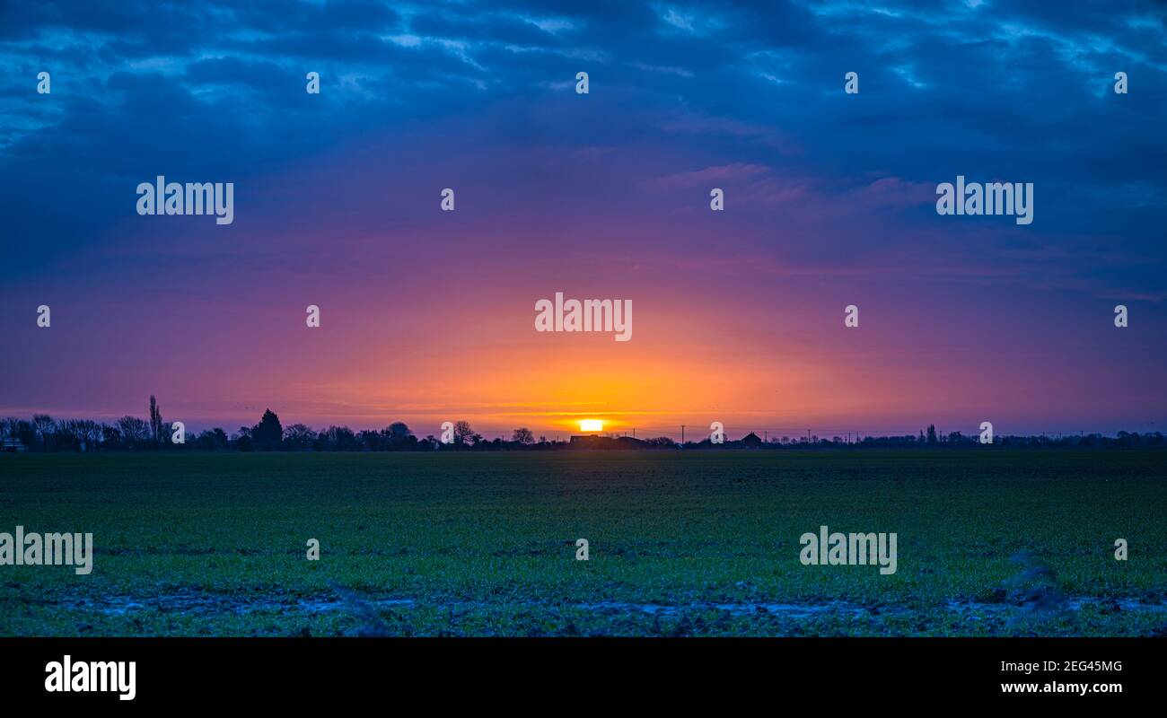 Spectaculaire lever de soleil d'hiver sur des terres agricoles plates Banque D'Images
