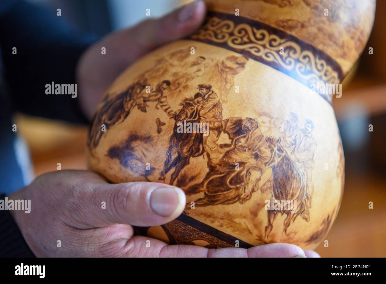 (210218) -- HORGOS, le 18 février 2021 (Xinhua) -- CAO Guangyao vérifie les œuvres de calabash pyrographique dans son studio à Horgos, dans la région autonome de Xinjiang Uygur, dans le nord-ouest de la Chine, le 6 février 2021. CAO Guangyao est un agriculteur de 45 ans à Horgos. Il est également connu par les habitants comme un artiste pour ses œuvres pyrographiques de calabash. En tant que passionné de peinture, Cao s'est intéressé à la création pyrographique il y a 8 ans à partir de séries TV et a commencé sa propre création depuis. En dépit de l'absence de formation professionnelle, Cao a fait des tentatives d'art à maintes reprises avec amour et passion pendant la saison de ralentissement de pr agricole Banque D'Images