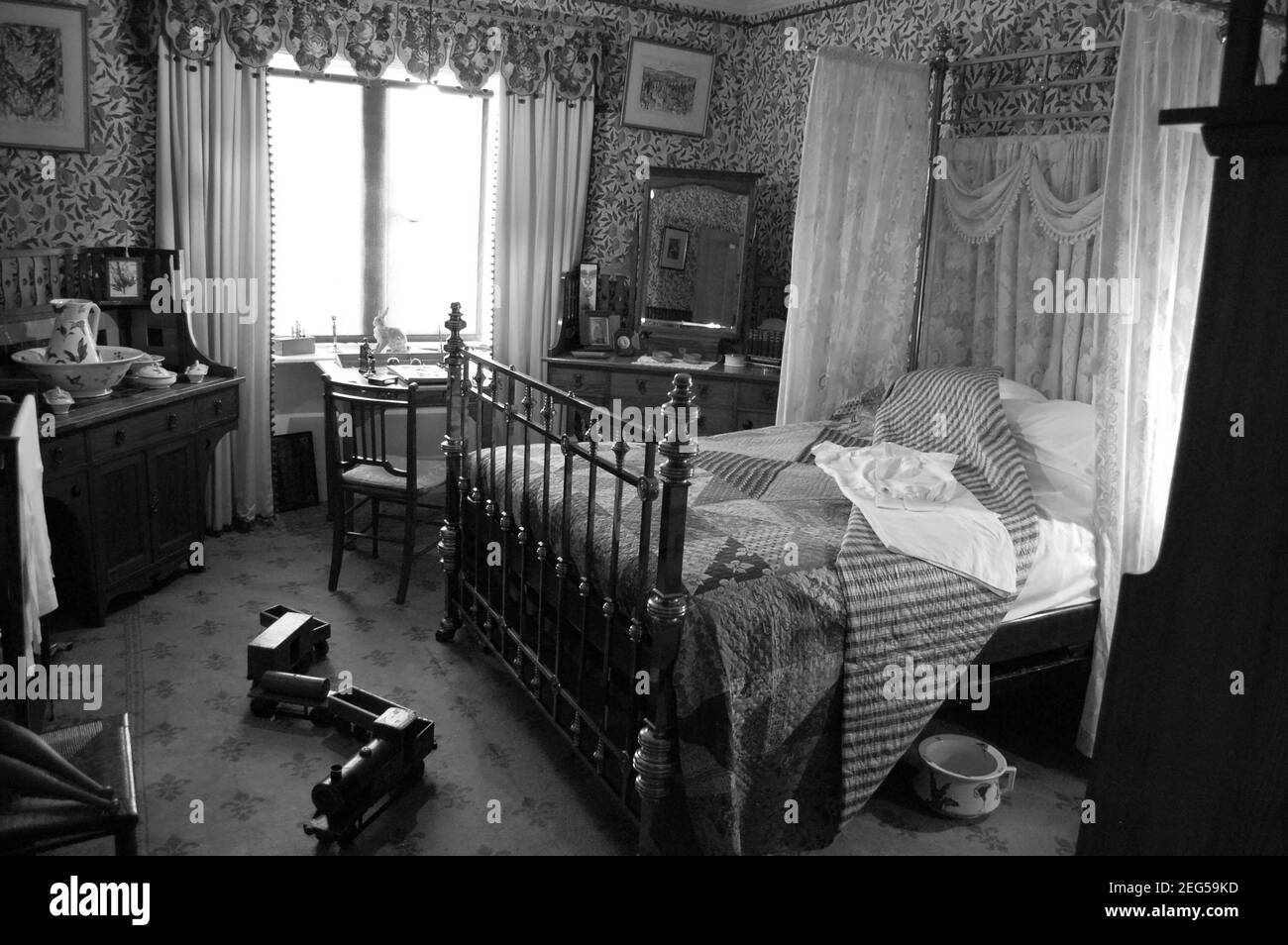Ancien lit victorien dans Cragside Royaume-Uni chambre à coucher Cragside fer à repasser rideaux métal chaise train bois pot bol couverture tapis rideaux image photos lapin Banque D'Images