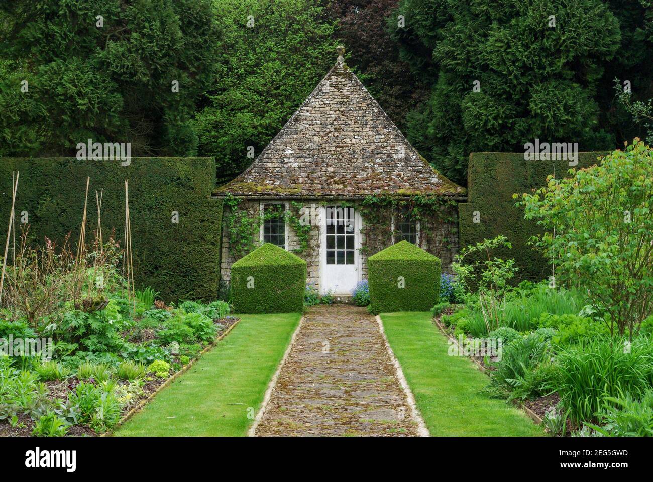 Rodmarton Manor, et maison de style art et artisanat, près de Cirencester, Gloucestershire, Royaume-Uni; dans le long jardin avec Am chemin menant au Pavillon. Banque D'Images