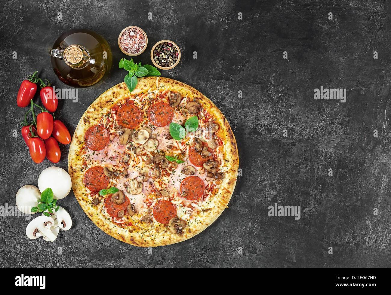 Pizza italienne chaude à Naples avec jambon et champignons à l'obscurité arrière-plan Banque D'Images