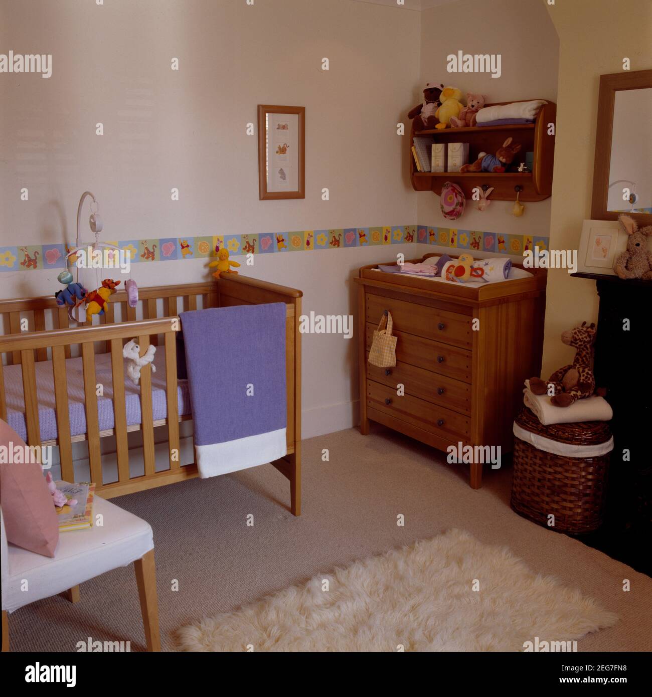 Lit bébé et coffre en bois dans la chambre des enfants avec dado décoratif bande Banque D'Images