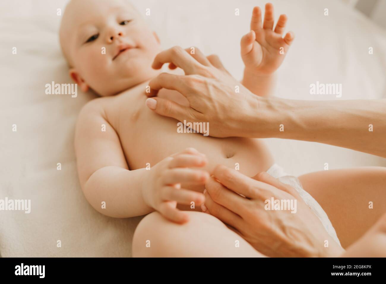 Massage De Bebe Maman Massage Le Ventre De Bebe Pendant La Colique Nouveau Ne Avec Colique Couche Sur Son Dos Sans Vetements La Main De Mere Sur Son Ventre L Aide Photo Stock