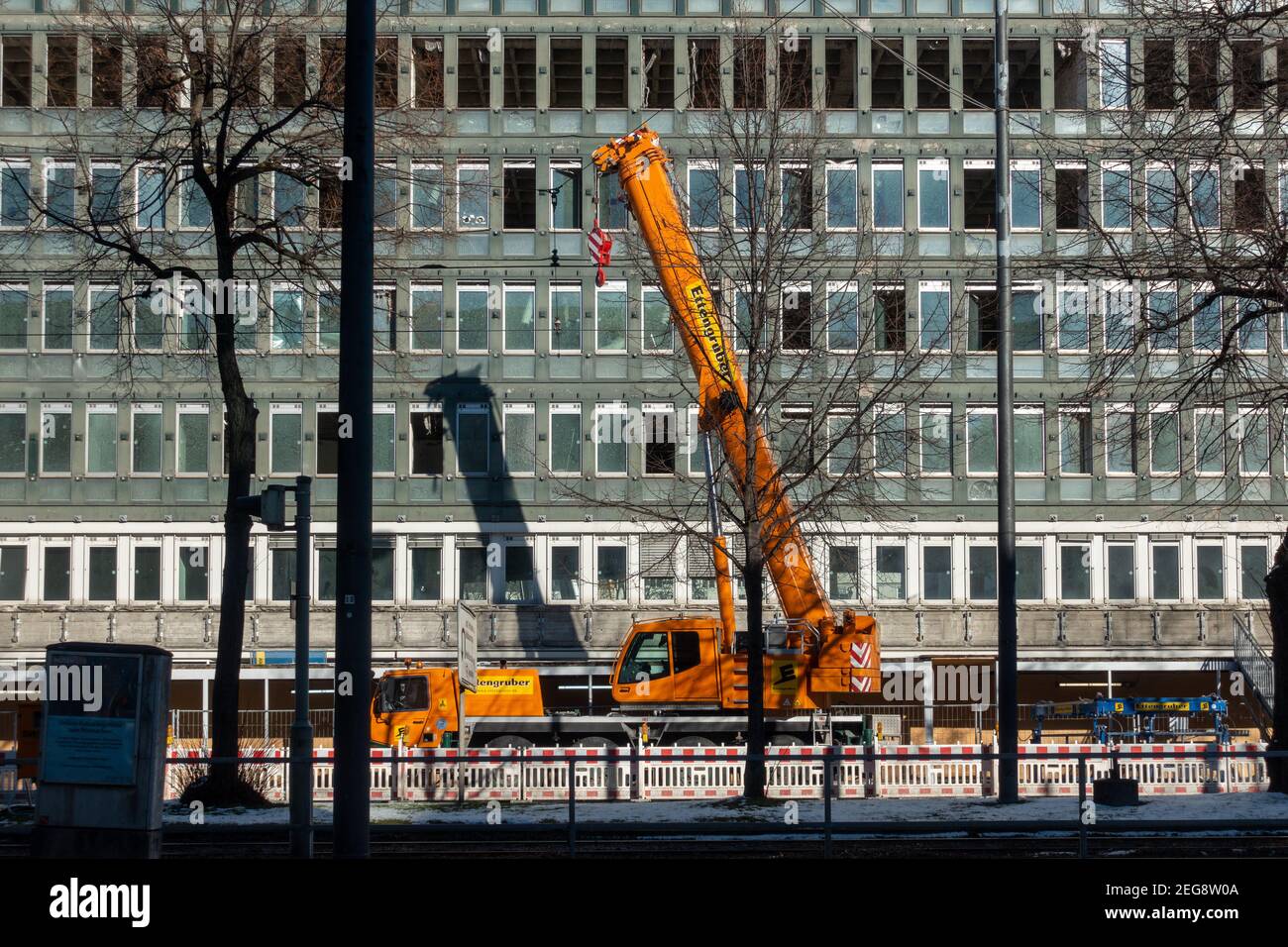 Munich, Allemagne - 13 février 2021 : grue orange vif sur le chantier de construction au centre de la ville. Le secteur de la construction est en plein essor à Munich. Banque D'Images