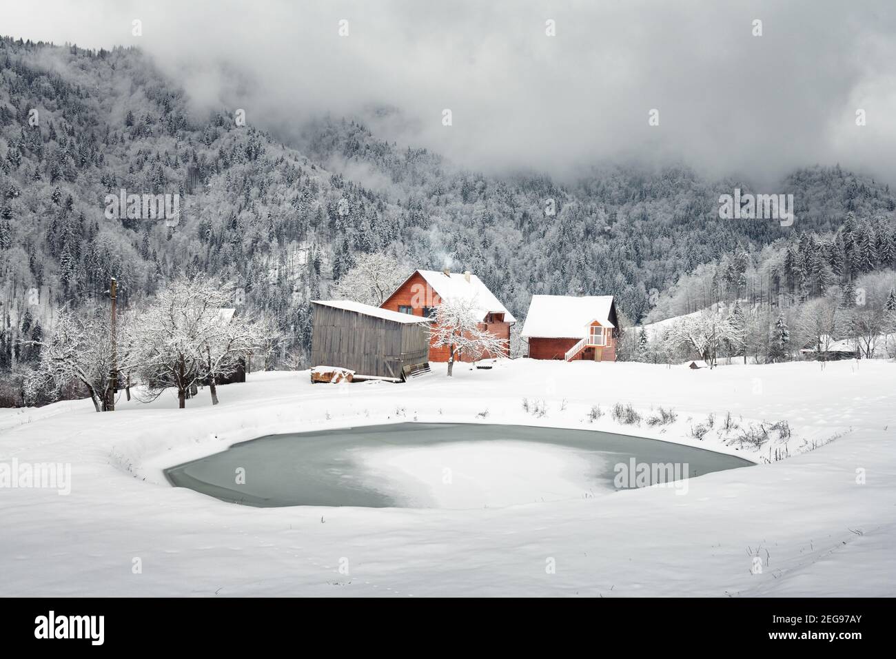 Paysage fantastique avec des montagnes enneigées, des arbres et des maisons. Carpathian montagnes, Ukraine, Europe Banque D'Images