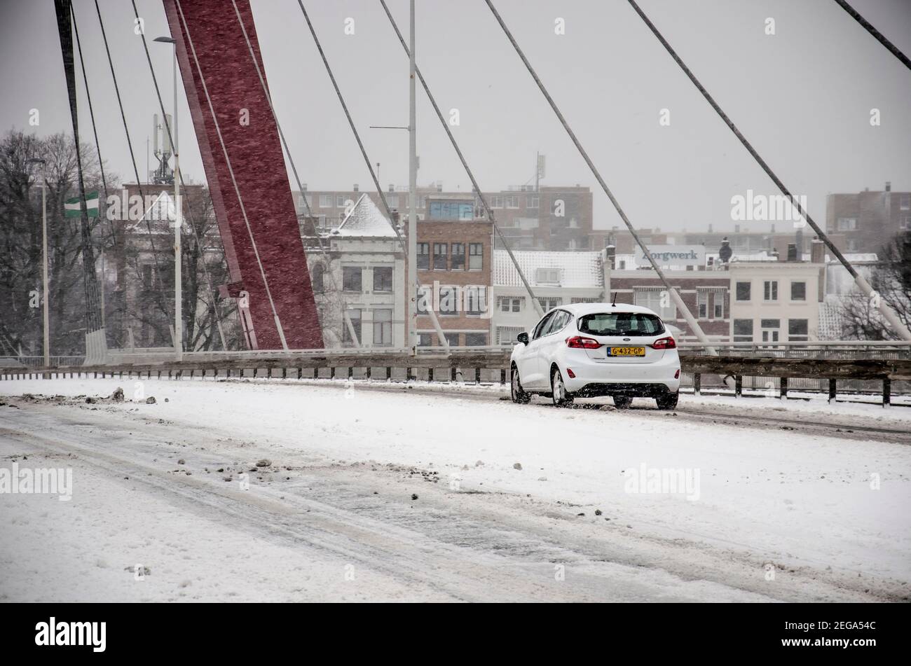 Rotterdam, pays-Bas, le 7 février 2021 : voiture blanche traversant le pont Willems couvert de neige pendant un blizzard par une journée froide en hiver Banque D'Images
